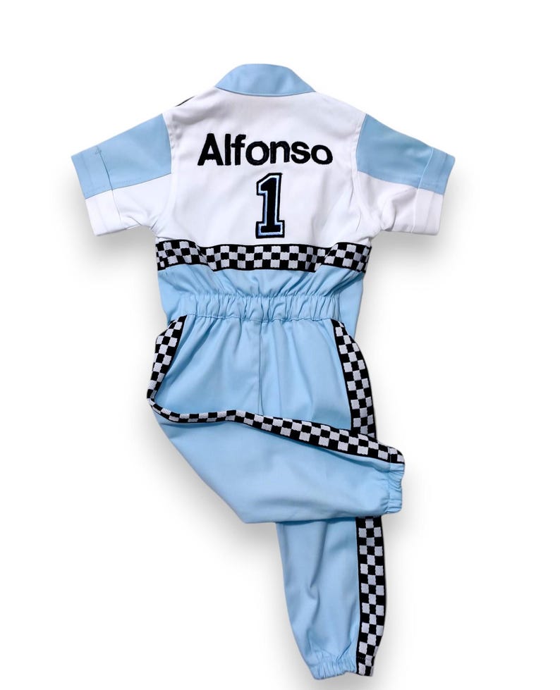 May include: A light blue jumpsuit with black and white checkered trim. The back of the jumpsuit has the name "Alfonso" and the number "1" in black.
