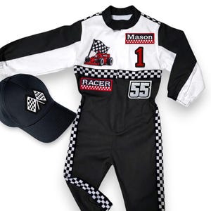 May include: A black and white racing suit with a matching baseball cap. The suit features a checkered flag, a red race car, the number 1, and the number 55. The cap has a checkered flag design. The name "Mason" is on the suit.