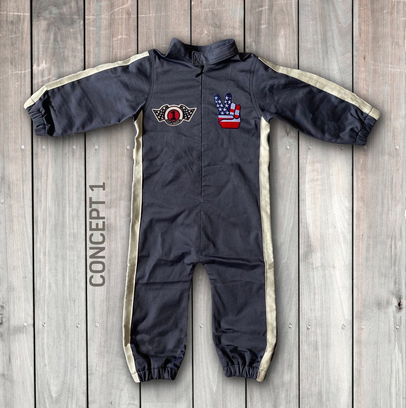 May include: A dark gray jumpsuit with white stripes down the sides. The jumpsuit has a zipper in the front and a patch on the chest with a number one and wings. There is also a patch on the right side of the chest with a peace sign and an American flag.
