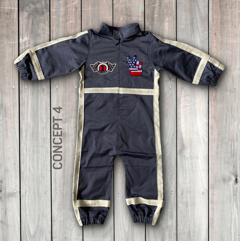 May include: A dark gray jumpsuit with white trim and patches. The patches feature a peace sign with an American flag design and a winged number one with the text "Champion". The text "CONCEPT 4" is written vertically on the left side of the image.