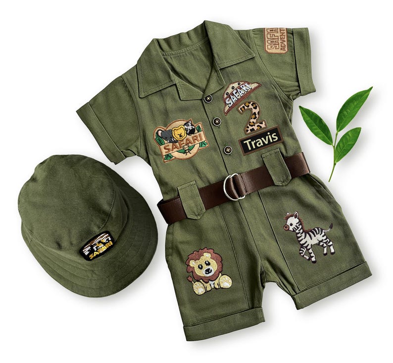 Short-sleeved version of the personalized safari costume jumpsuit, perfect for summer birthdays and outdoor events. Shown with a standard safari hat and custom "Travis" name patch, this set is ideal for a safari nursery decor theme or scout party.