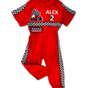 Children’s red racer costume with hat – stylish jumpsuit featuring a race car patch, checkered flag embroidery, and “Racer” label. Custom name and number stitched on the back. Comes with matching red cap. Perfect for boys or girls at parties and events.