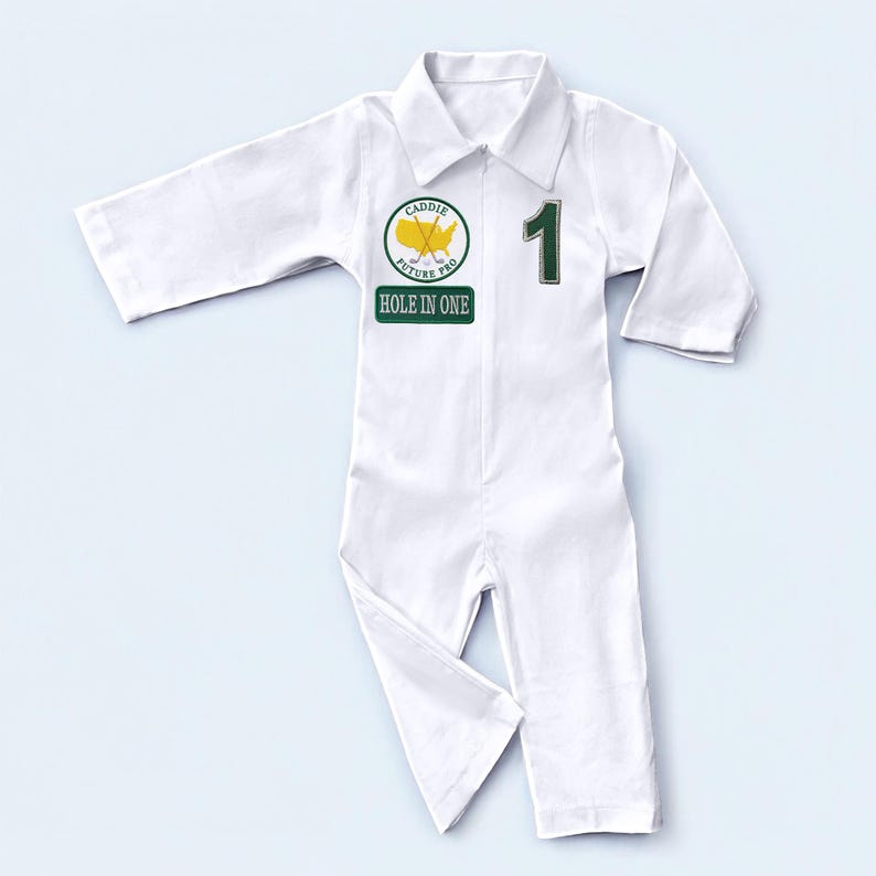 A vertical full-length photo of the white cotton golf caddy coverall. From the hem of the pants to the top of the collar, this shot demonstrates the proportions and fit of the outfit. The contrasting green graphics against the crisp white fabric create a classic, sporty look inspired by traditional golf tournament caddy gear.