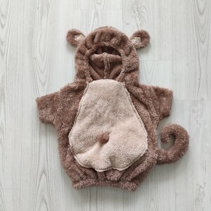 Puede incluir: Disfraz de mono de peluche marr&oacute;n para beb&eacute; o ni&ntilde;o peque&ntilde;o. El disfraz tiene una capucha con orejas y una cola.