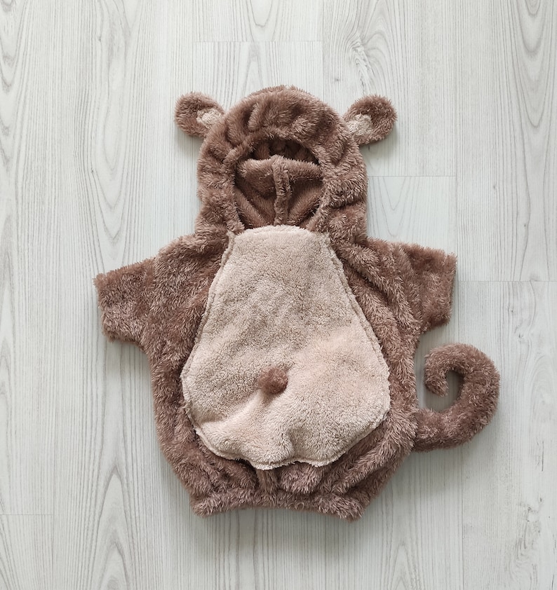 Puede incluir: Disfraz de mono de peluche marr&oacute;n para beb&eacute; o ni&ntilde;o peque&ntilde;o. El disfraz tiene una capucha con orejas y una cola.