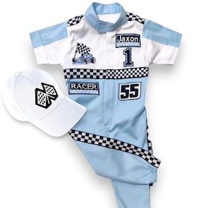 May include: A light blue racing suit with black and white checkered accents. The suit has a white patch with a cartoon race car and a checkered flag, a white patch with the word "RACER", a white patch with the number "55", and a white patch with the name "Jaxon" and the number "1". A white baseball cap with a black checkered flag design is included.