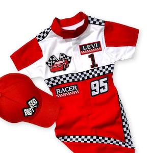 Peut inclure: Ensemble de course rouge et blanc avec une casquette de baseball assortie. L'ensemble comprend le numéro "1" et "95", le nom "LEVI" et le mot "RACER". Des drapeaux à damier et des graphiques de voiture sont également présents.
