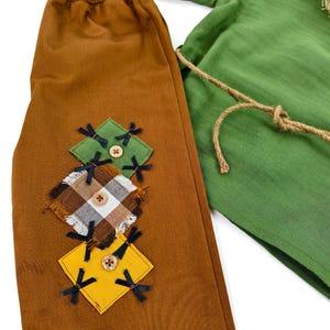 Adorable fall-themed baby costume inspired by classic scarecrow designs. Comfortable and breathable outfit with button closure and handmade touches.