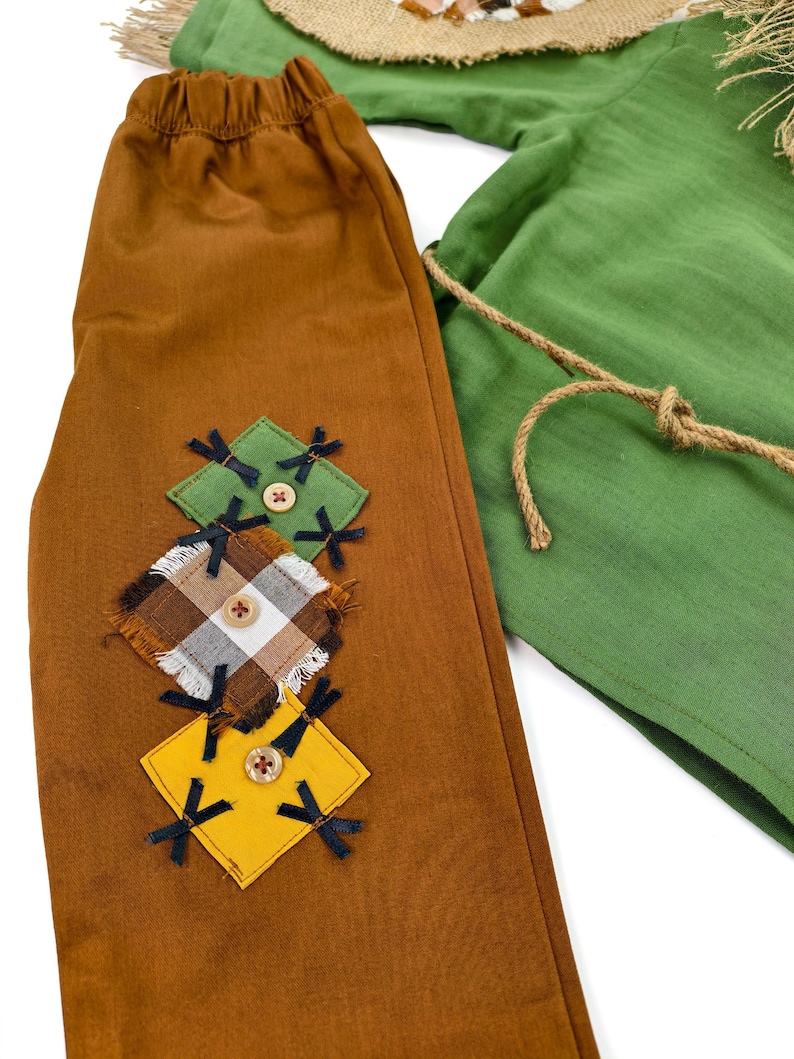 Adorable fall-themed baby costume inspired by classic scarecrow designs. Comfortable and breathable outfit with button closure and handmade touches.
