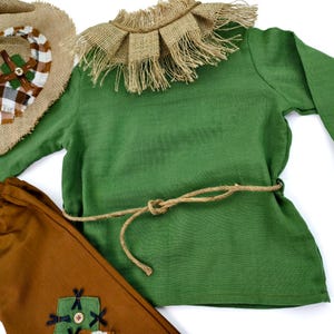 Scarecrow costume set for kids featuring a rustic hat, faux stitched patches, and a soft dress or romper design. Great for Wizard of Oz-inspired looks or autumn events.