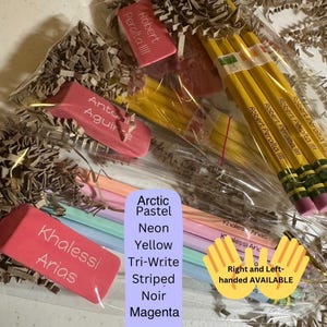 May include: Several sets of personalized yellow and pastel pencils paired with rectangular pink erasers, each individually packaged in clear plastic with brown paper filler. The pencils are imprinted with names like Robert Peralta III and Khalessi Arias.
