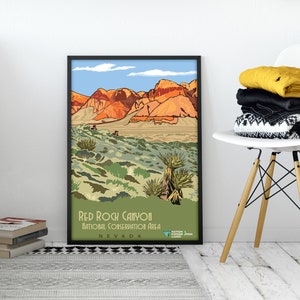 K&ouml;nnte beinhalten: Ein Vintage-Poster mit einer malerischen Aussicht auf das Red Rock Canyon National Conservation Area in Nevada. Das Poster zeigt eine Landschaft mit roten Felsformationen, W&uuml;stenvegetation und einem blauen Himmel mit Wolken. Der Text "Red Rock Canyon National Conservation Area Nevada" ist am unteren Rand des Posters gedruckt.
