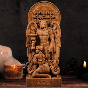 Pode incluir: Estátua de madeira esculpida de uma figura alada segurando um cálice, com uma figura ajoelhada abaixo. A estátua tem um emblema circular acima da cabeça da figura e a palavra "SITRY" na base. A estátua é marrom.
