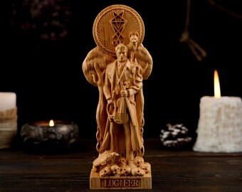 May include: A wooden statue of Lucifer, featuring a figure holding a violin, with a dog and a symbol above. The base reads "LUCIFER". The statue is surrounded by candles and skulls, creating a dark, gothic aesthetic.