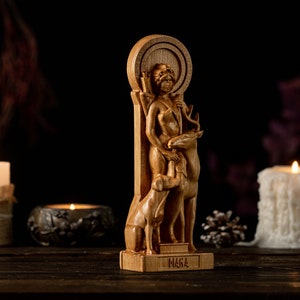 May include: A wooden statue of a woman with a deer and a dog. The statue is carved in a detailed style and has a rustic look. The woman is holding a bow and arrow. The statue is standing on a wooden base with the word "MARA" inscribed on it.