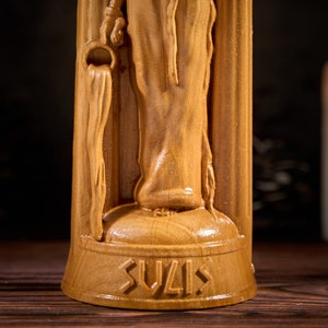 May include: A wooden statue of a woman holding a pitcher, with the word "SUVIS" carved into the base.