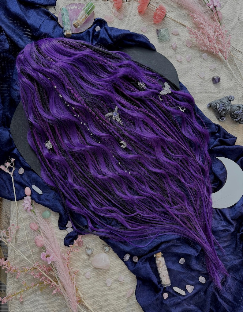 a purple wig with intricate braids and various crystals and flowers scattered around it, creating a mystical and enchanting atmosphere.