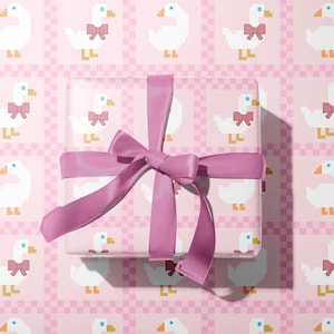 May include: A wrapped gift with a pink ribbon on a pink background. The wrapping paper and background feature a repeating pattern of white pixelated geese wearing pink bows.