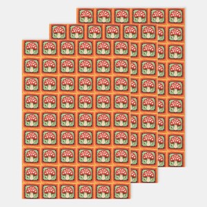 May include: A repeating pattern of red and white mushrooms with green stems in orange squares on a white background. The pattern is repeated three times.