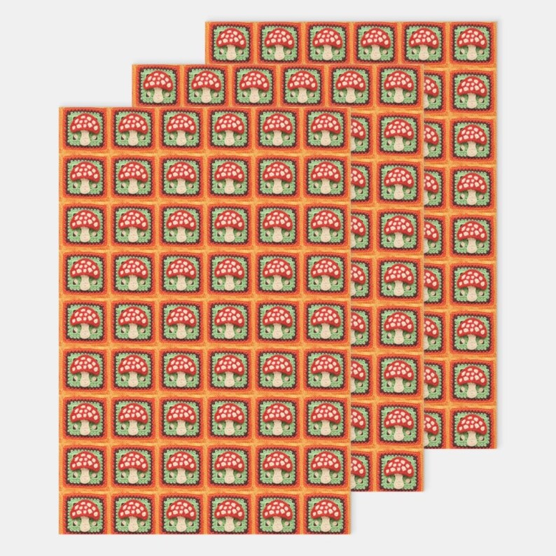May include: A repeating pattern of red and white mushrooms with green stems in orange squares on a white background. The pattern is repeated three times.