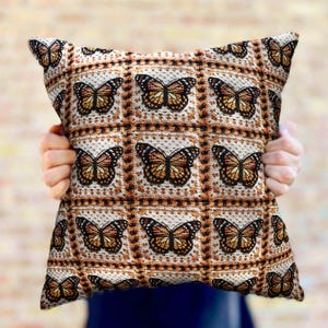 May include: A decorative throw pillow with a pattern of brown butterflies on a white background. The pillow is made of a soft, textured fabric.