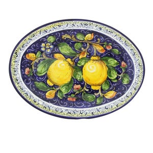 May include: Oval ceramic serving platter with a hand-painted design. The dark blue surface features two yellow lemons on a branch with green leaves and small flowers. The rim has a decorative border with a yellow and white pattern.