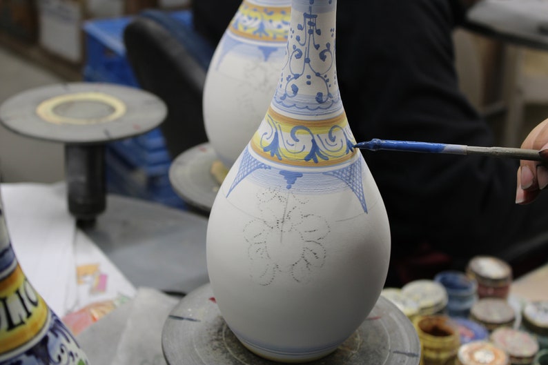 Our master painter is decorating the oil bottle