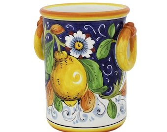 May include: A ceramic vase with a vibrant lemon and floral design. The vase features a navy blue background with yellow lemons, green leaves, and white flowers. It has two yellow handles and a yellow and orange rim.