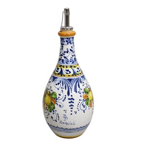 May include: A white ceramic oil bottle with a decorative floral design in yellow, green, and blue. The bottle has a silver spout and a cork-like top. The words "Borgioli" are written on the bottle.