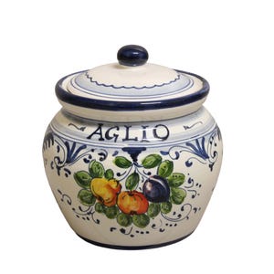 Könnte beinhalten: Weißer Keramiktopf mit Deckel, verziert mit blauen Blumenmustern und dem Wort "AGLIO". Der Topf zeigt ein lebendiges Fruchtdesign mit gelben, orangen und violetten Elementen. Ideal für die Küche.