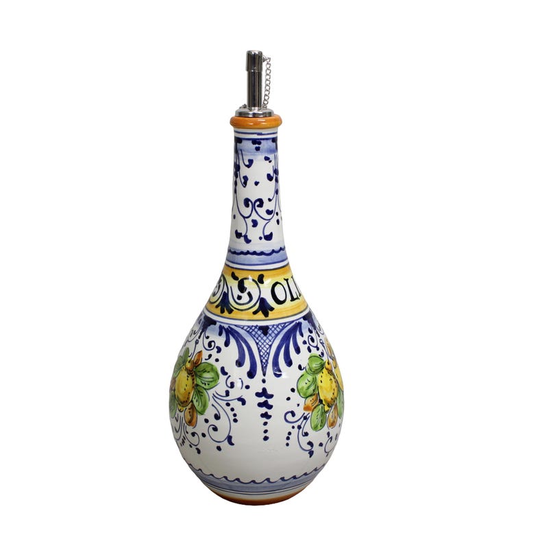 May include: A white ceramic olive oil bottle with a decorative design. The bottle features a long neck and a bulbous body, adorned with blue, yellow, and green floral patterns. The word "OLIO" is visible on the bottle. A metal spout is at the top.