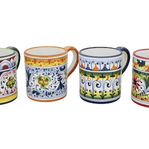 Puede incluir: Cuatro tazas de cerámica con coloridos diseños florales y geométricos. Cada taza tiene un color de asa diferente, incluyendo verde, naranja, azul y rosa. Las tazas están decoradas con intrincados diseños en varios colores, incluyendo amarillo, azul y rojo.