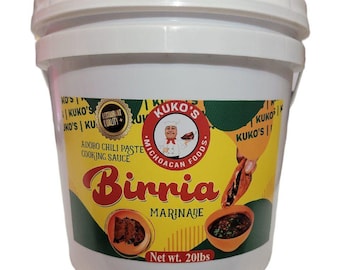 May include: A white plastic bucket with a yellow and green label. The label says "Kuko's Michoacan Foods" and "Birria Marinade". The bucket contains 20 pounds of Birria Marinade.