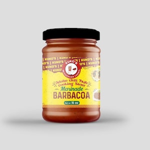 May include: A yellow and red label on a glass jar of Adobo Chili Paste Cooking Sauce Marinade for Barbacoa. The label has the text "Kuko's" and "Net wt 16 oz".
