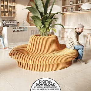Puede incluir: Un banco de madera con forma de cuenco grande y redondeado con una planta creciendo en el centro. El banco está hecho de madera marrón claro y tiene un acabado natural. El banco está en un café moderno con una persona sentada en él.