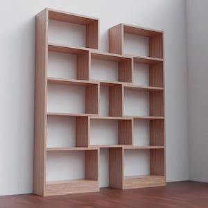 K&ouml;nnte beinhalten: Ein gro&szlig;es, h&ouml;lzernes B&uuml;cherregal mit mehreren Regalbrettern und F&auml;chern. Das B&uuml;cherregal ist aus hellbraunem Holz gefertigt und hat ein modernes Design.