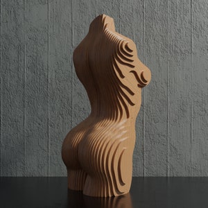 May include: A wooden sculpture of a human torso with a layered, abstract design. The sculpture is made of light brown wood and has a smooth, polished finish.