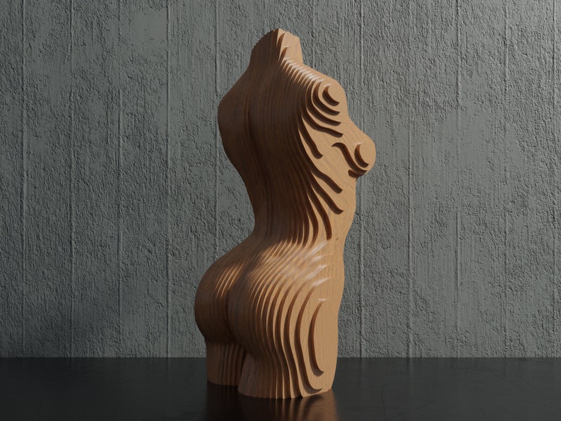 May include: A wooden sculpture of a human torso with a layered, abstract design. The sculpture is made of light brown wood and has a smooth, polished finish.
