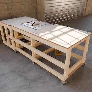 May include: A light-colored wooden workbench on casters featuring a built-in table saw with a blade guard. The top surface includes a grid of holes on one side and a flat, smooth panel on the other, supported by an open frame structure.