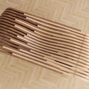 K&ouml;nnte beinhalten: Eine gebogene Holzbank aus abwechselnd hellen und dunklen Holzlatten. Die Bank steht auf einem Holzboden.