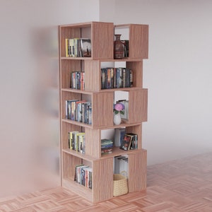 K&ouml;nnte beinhalten: Ein B&uuml;cherregal aus Holz mit mehreren Regalbrettern, jedes mit unterschiedlich gro&szlig;en F&auml;chern. Die Regalbretter sind mit B&uuml;chern, einer Vase mit rosa Blumen und einem Weidenkorb gef&uuml;llt.