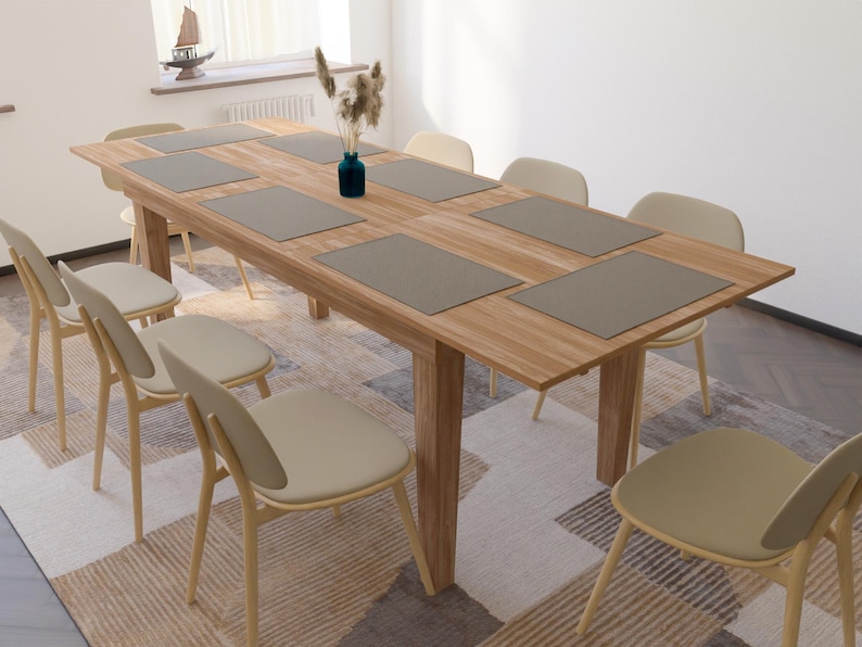 May include: A wooden dining table with six chairs and gray placemats. The table is set with a vase of flowers in the center.