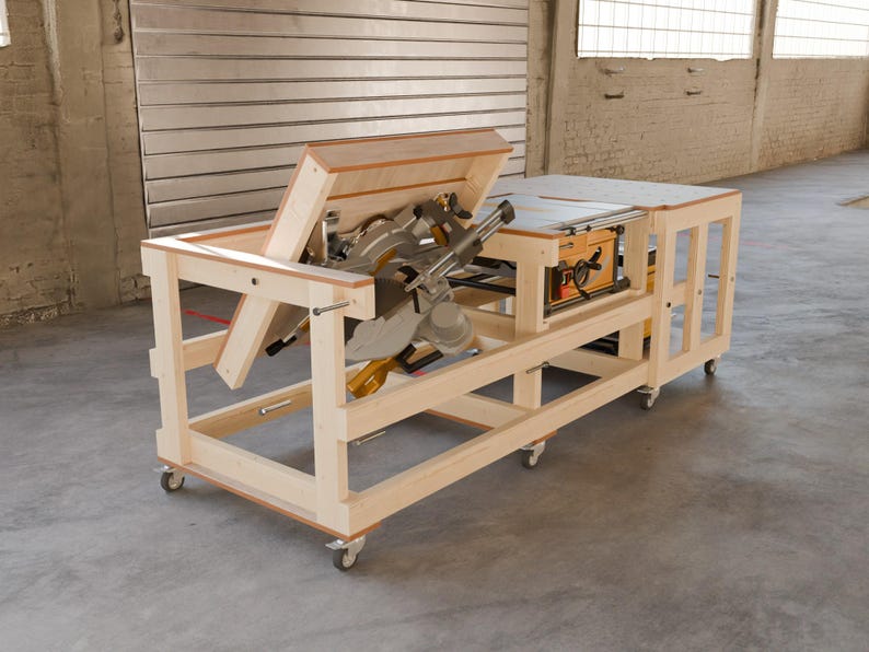 May include: A light-colored wooden workbench on casters featuring an integrated miter saw mounted on a flip-top mechanism and a table saw embedded into the flat surface. The structure is constructed from light wood beams with a modular design.