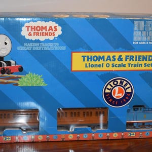 May include: A boxed Thomas & Friends Lionel O Scale Train Set. The box is blue with images of Thomas the Tank Engine and train cars. The box has the Thomas & Friends logo and the Lionel logo.