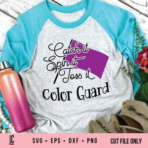 Könnte beinhalten: Ein graues und türkisfarbenes Raglan-T-Shirt mit dem Text "Catch it Spin it Toss it Color Guard" und einer lila Flaggengrafik.