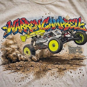 Peut inclure: T-shirt de couleur claire avec un motif d'une voiture de course RC soulevant de la terre. Le texte "WARREN CAMPBELL" est écrit dans un style graffiti. La voiture a des roues jaunes et un aileron jaune. Le texte "Sworkz S35-4e" est également visible.