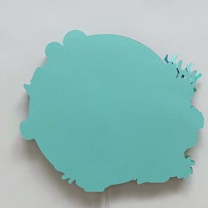 May include: A teal blue paper cutout of a stylized flower with a white background.