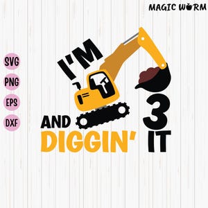 May include: A yellow excavator with a black bucket is digging in the dirt. The text "I'm 3 and Diggin' It" is written in yellow and black letters.
