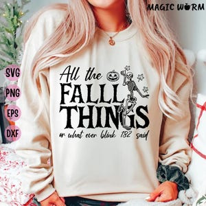 May include: A beige sweatshirt with the text "All the FALL THINGS or what ever blink 182 said" in black. The design includes a pumpkin, skeleton, and maple leaves, perfect for autumn and Halloween.