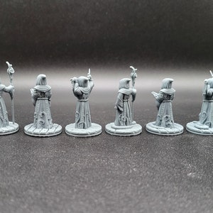 May include: Seven gray plastic miniature figures of robed wizards with staffs, each standing on a round base.